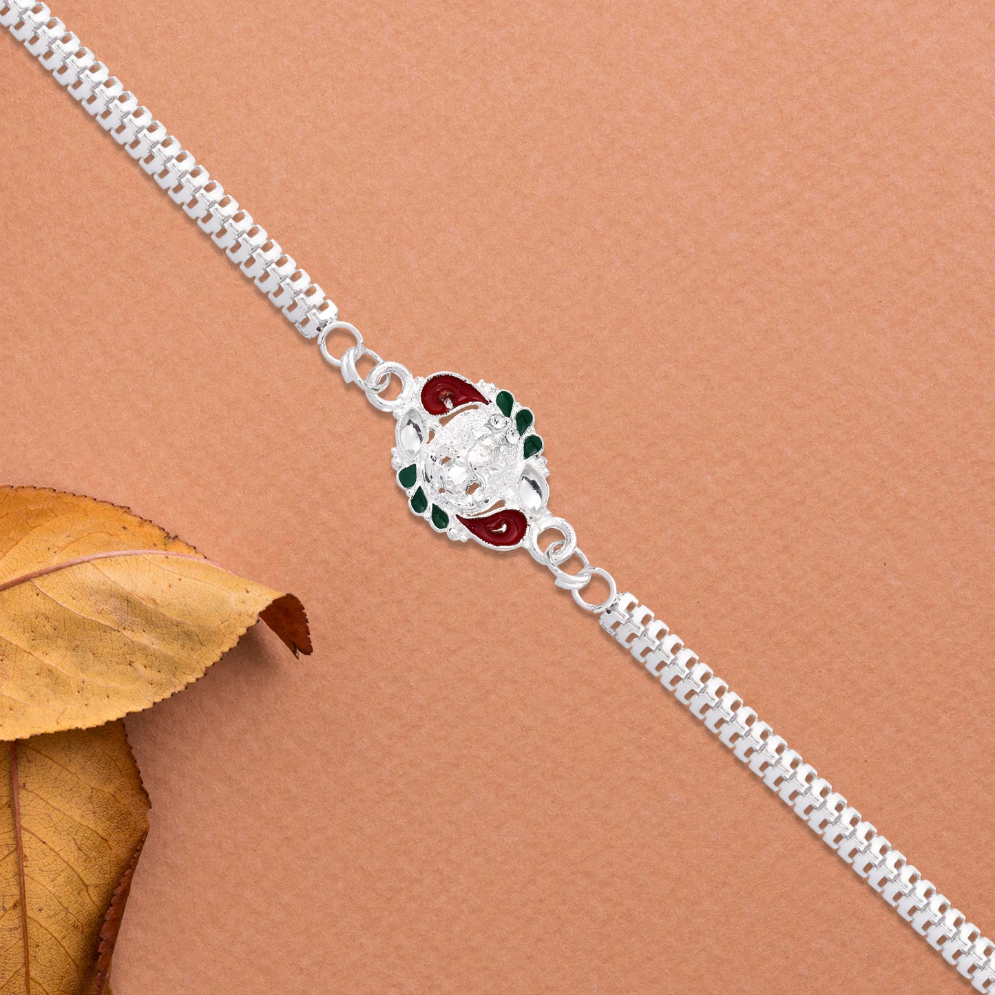 Designer Rakhi With Ornamental Floral Motif And Silver Finish Chain